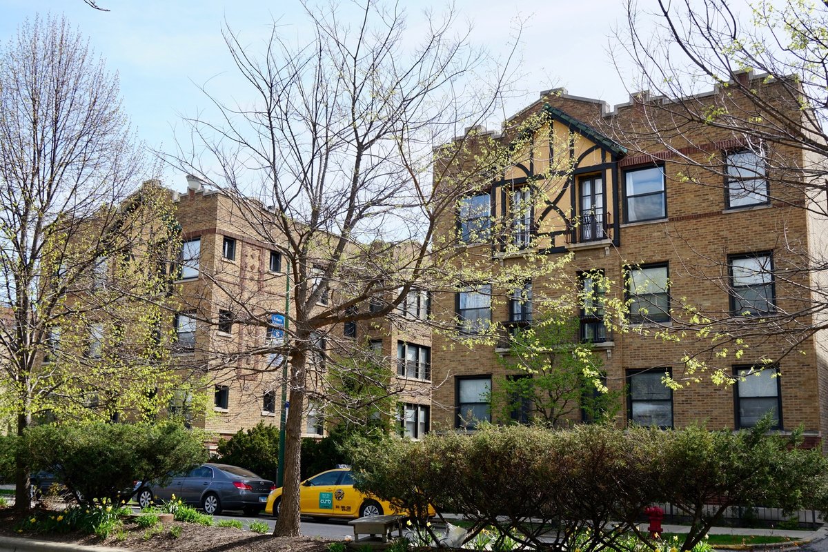 Brick multifamily buildings on a tree-lined Chicago street